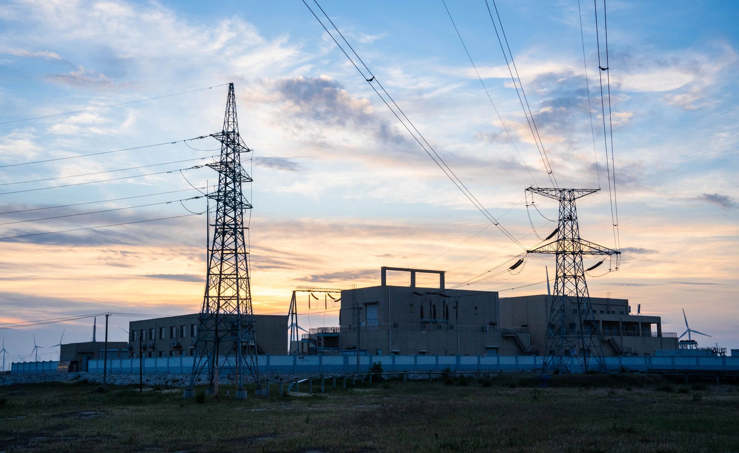 Electrical substation and transmission towers at dusk